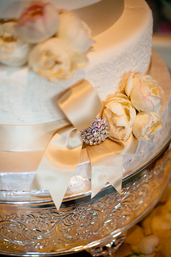 ivory wedding cake on silver cake stand and champagne ribbon detail - real wedding photo by Orange County photographers Boutwell Studio